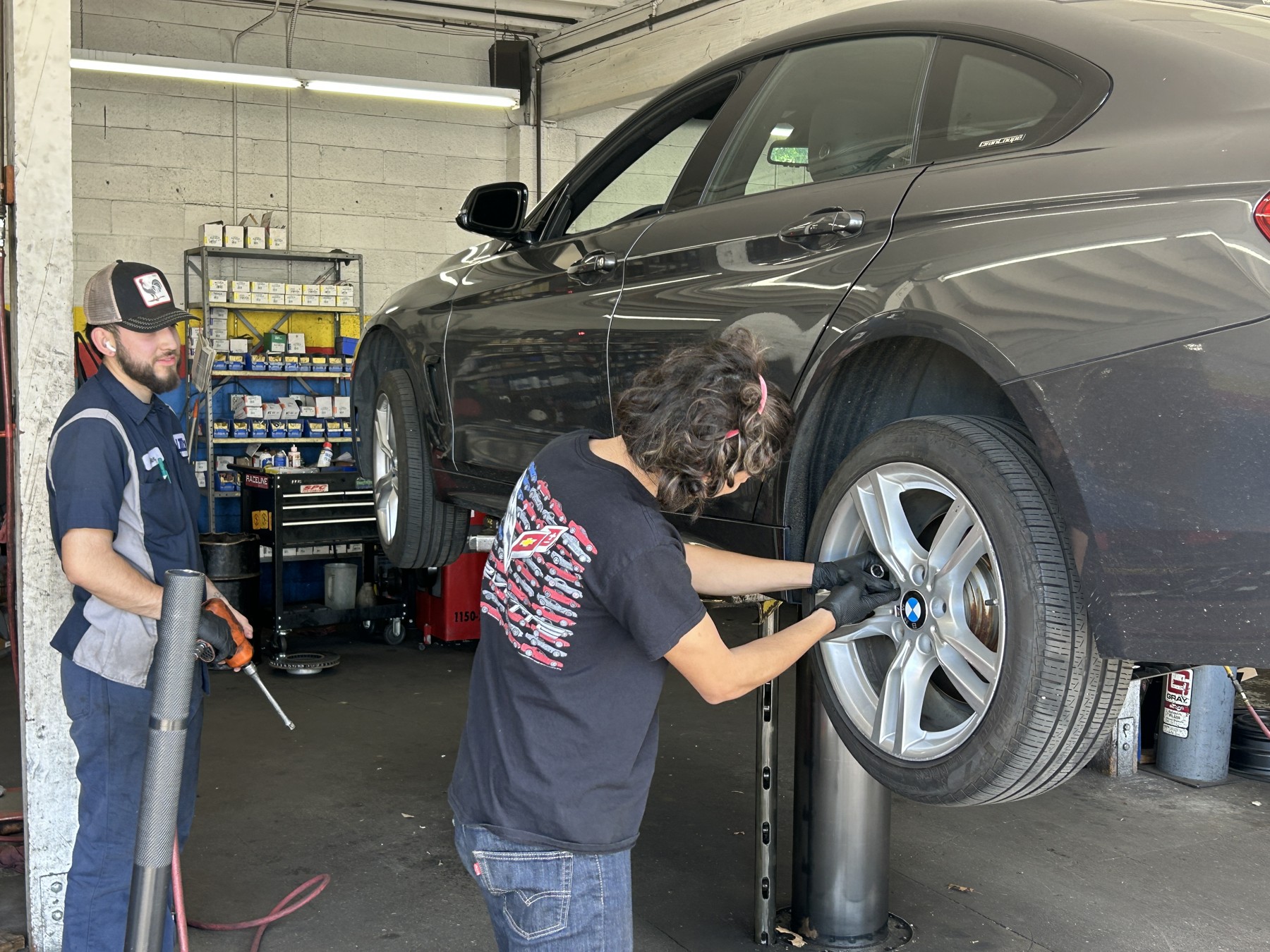 A student and mentor examining a raised car