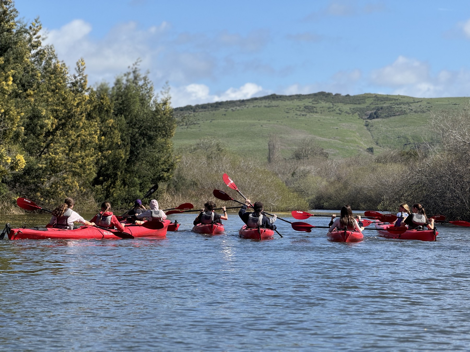 Students kayaking together on a river