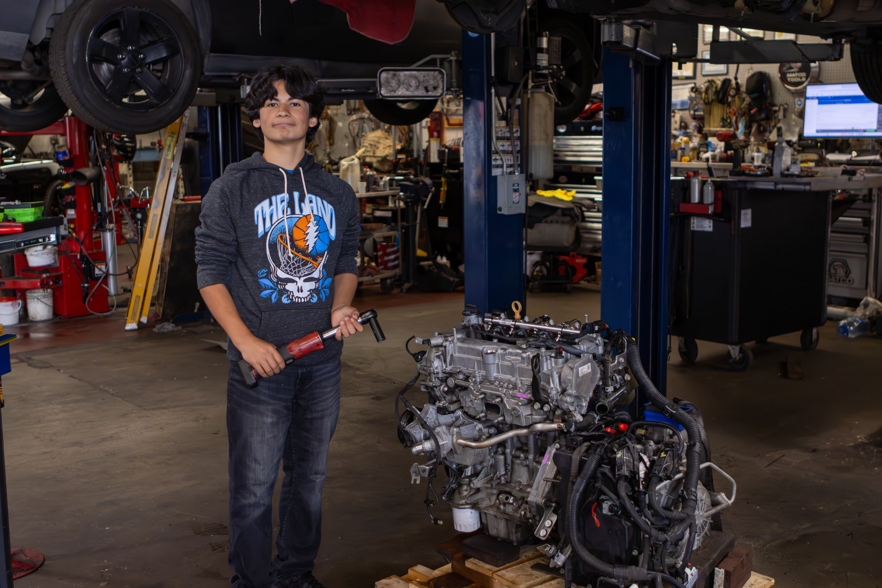 A participant beside an engine in an automotive workshop