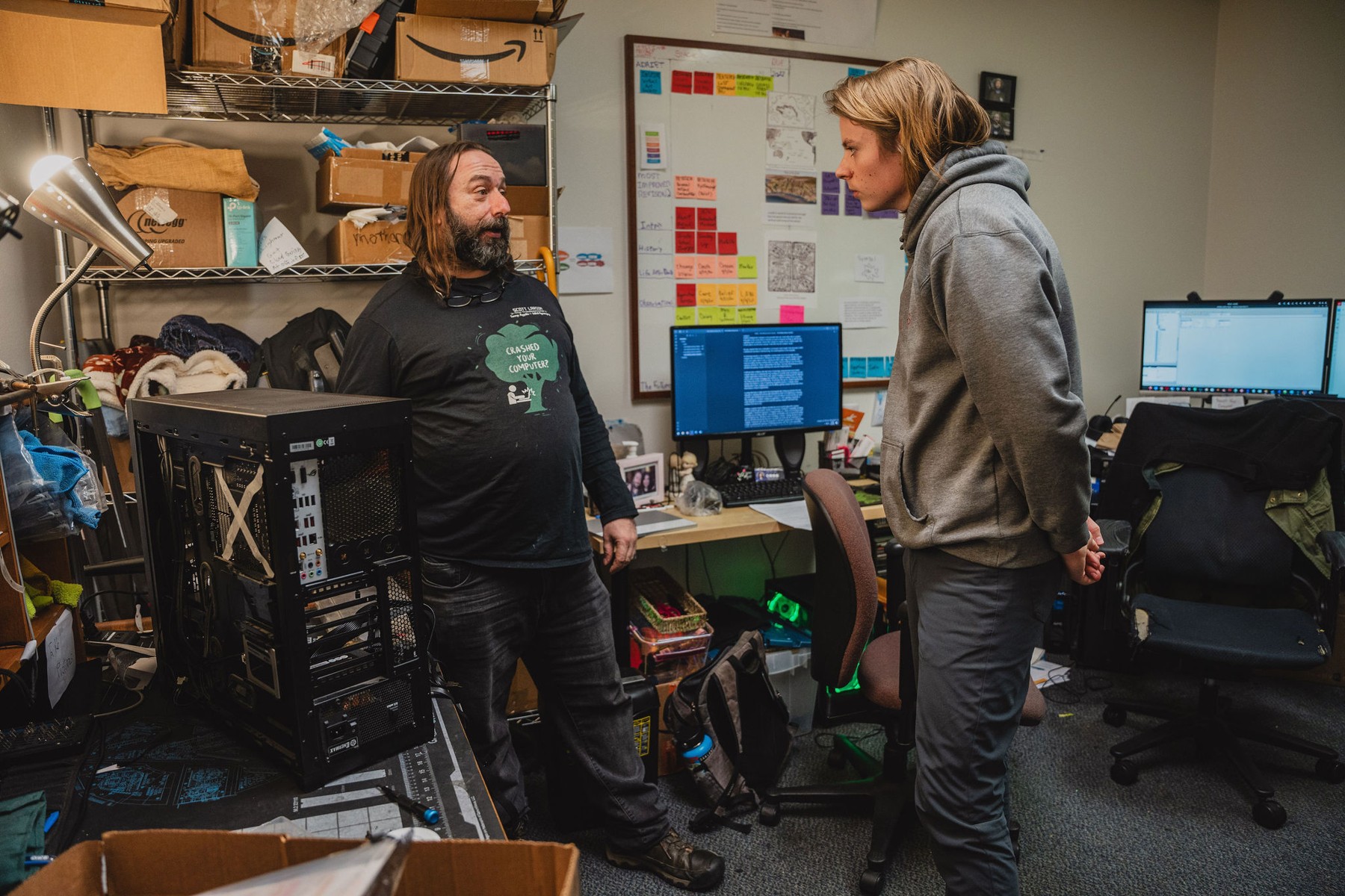 A student and mentor discussing computer hardware in a workshop